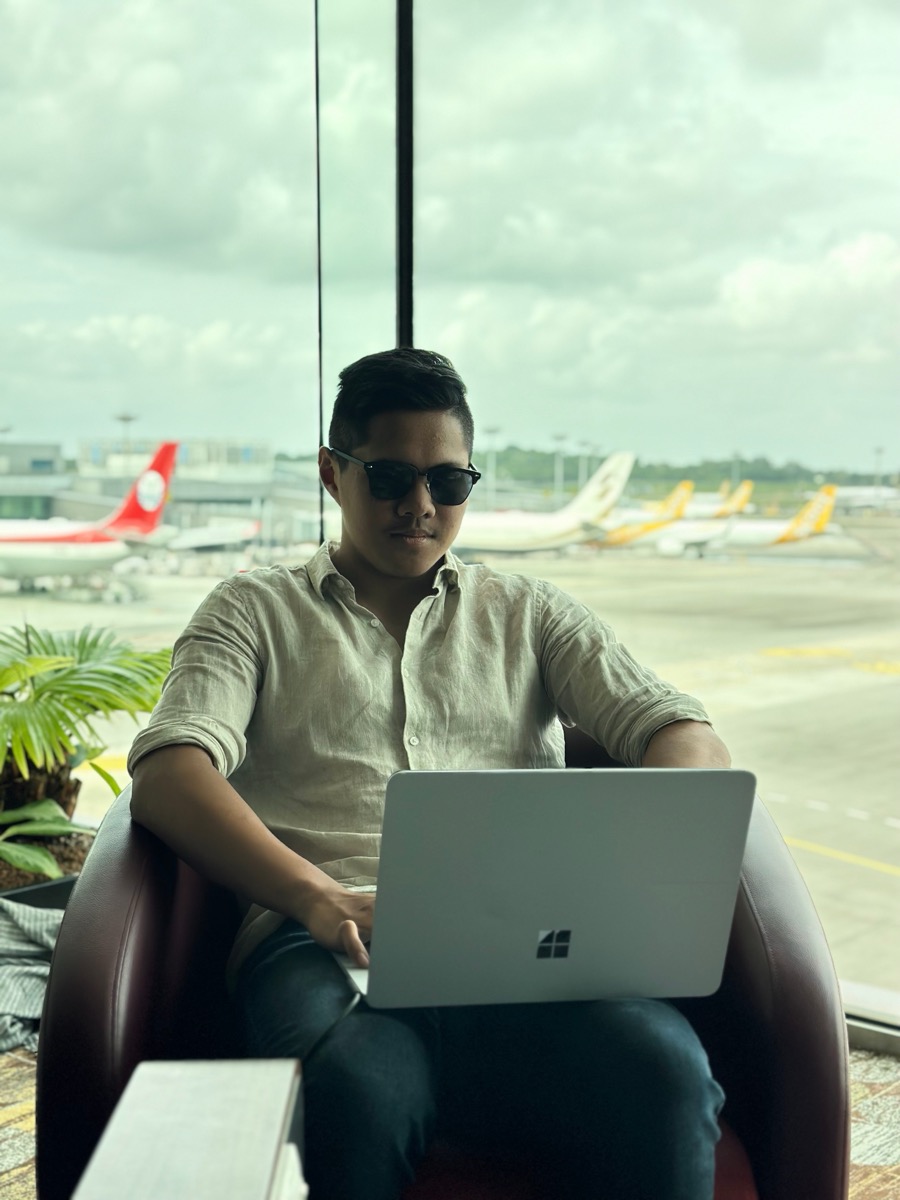 Zach working on a laptop in an airport lounge