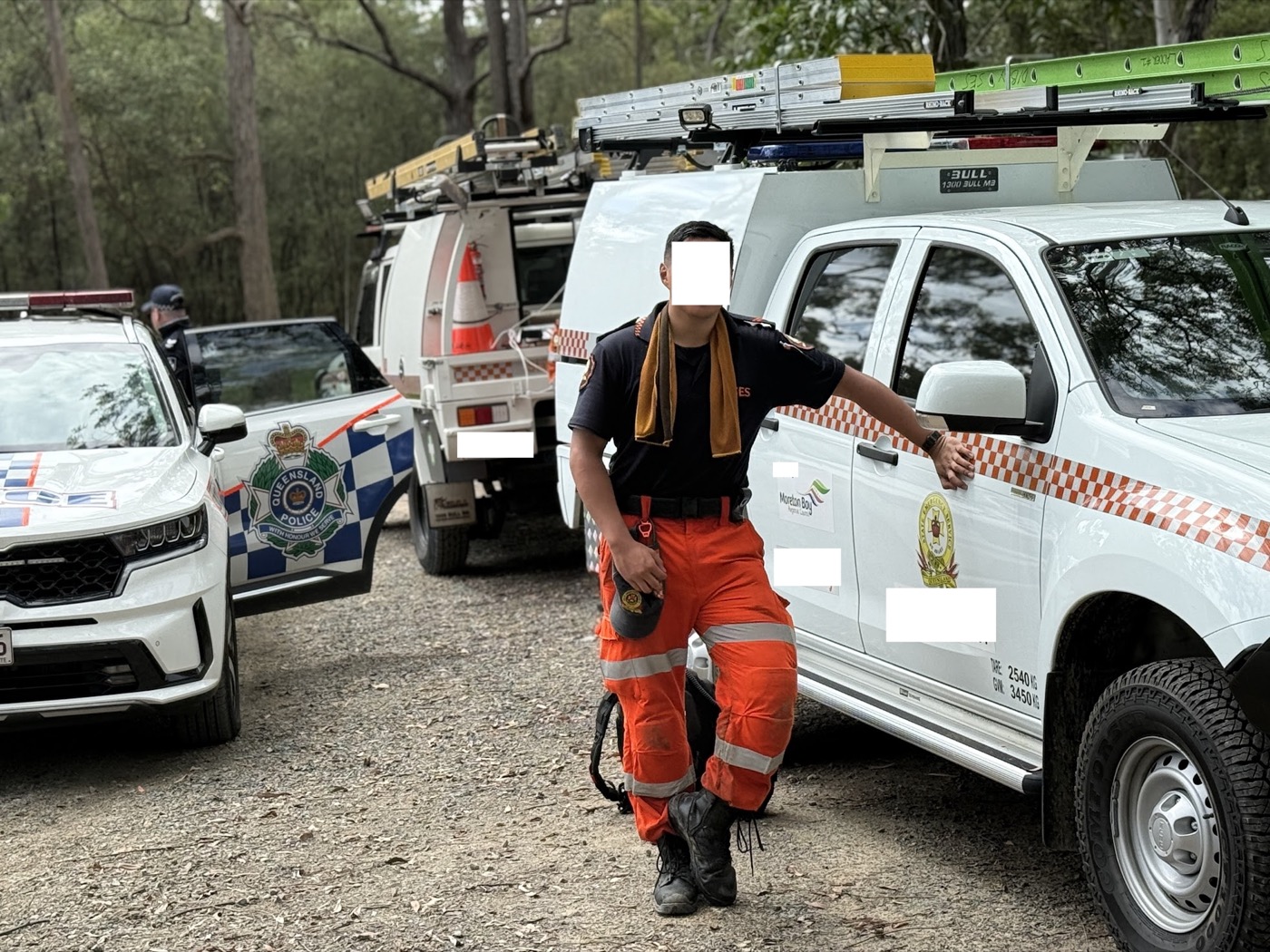 Zach in SES uniform beside emergency vehicles